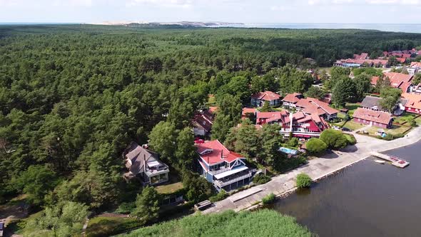 Beautiful town of Pervalka surrounded by dense pine forest on sunny day, aerial drone view alt