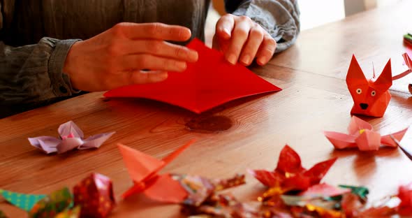 Woman preparing origami with paper at home 4k