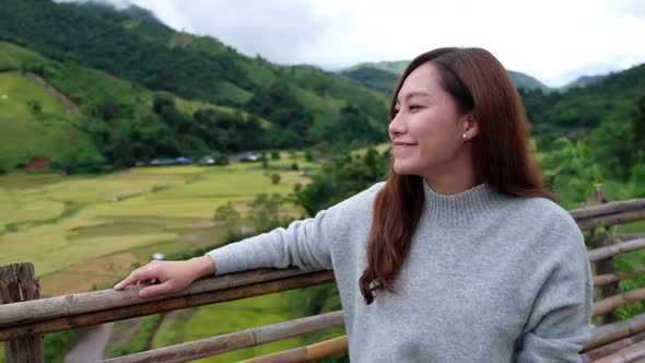 Slow motion of a woman with a paddy field or rice terrace and mountain views