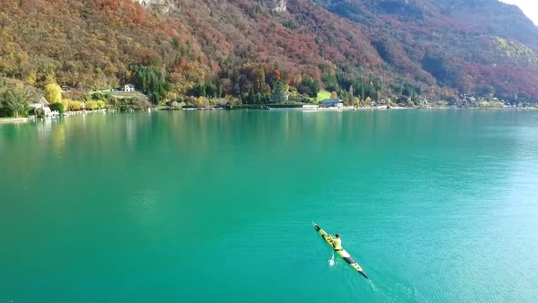 A kayaker paddles in a scenic mountain lake. alt
