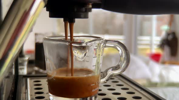 Up close view of fresh espresso being made and poured into glass SLOMO alt