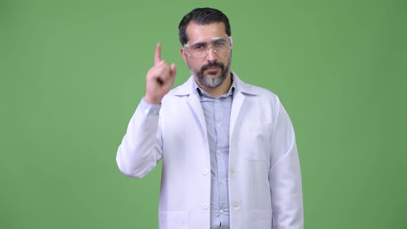 Handsome Persian Bearded Man Doctor Wearing Protective Glasses and Pointing Up