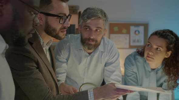 Company Employees Discussing Business Ideas Brainstorming Working in Office in the Evening alt