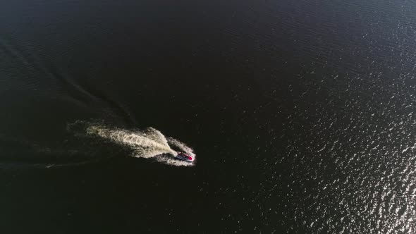 Aerial view of man ride a red and white jetski on the city pond 14 alt