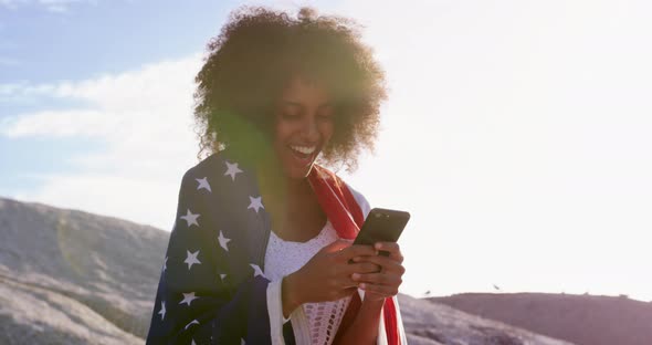 Woman wrapped with american flag and using mobile phone 4k