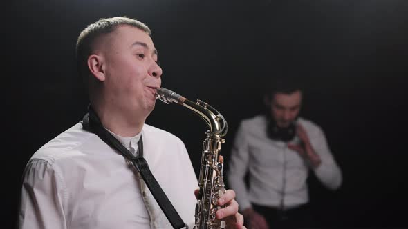 Close up of Energetic Saxophonist Man with Saxophone Standing in Nightclub Playing Sax