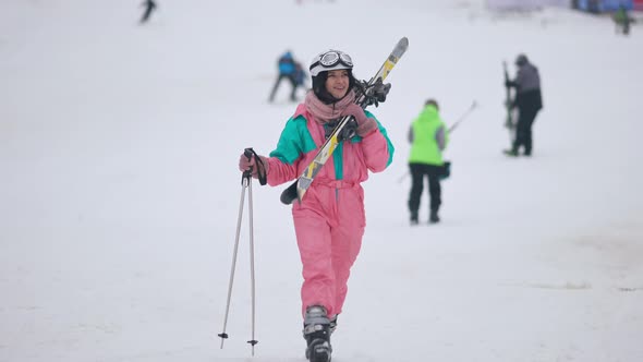 Wide Shot of Excited Slim Caucasian Woman in Ski Suit Walking to Camera in Slow Motion alt