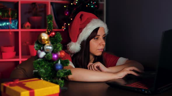 Young Woman in Santa Costume Works at Computer in Office alt