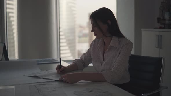 Silhouette of a Business Woman Working Late in the Evening in the Office alt