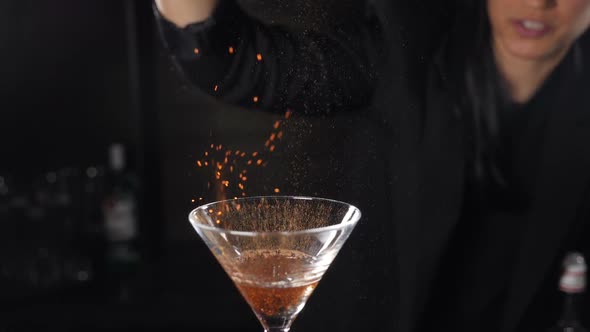 Bartender Sets Fire To Cocktail, Burning Cinnamon in Alcohol Drink on Black Background. Flames in alt