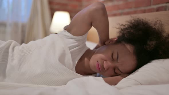 African Woman Having Neck Pain While Sleeping in Bed alt