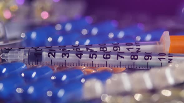 Two Syringes Lay on Different Pills, Rotation, Reflection, Macro, on Black, Back Light alt