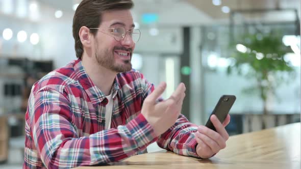 Cheerful Male Designer Doing Video Call on Smartphone alt