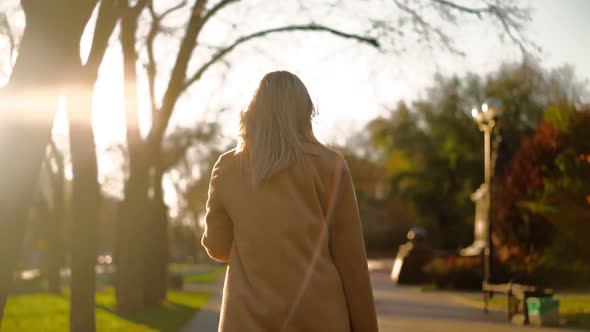Unrecognizable Beautiful Business Woman Walks Through Sunset City Park To Work  alt