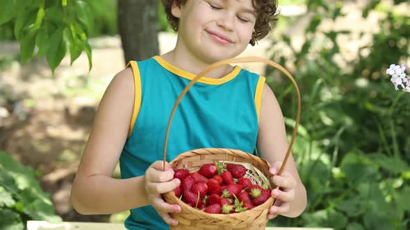 A boy holds a basket full of berries