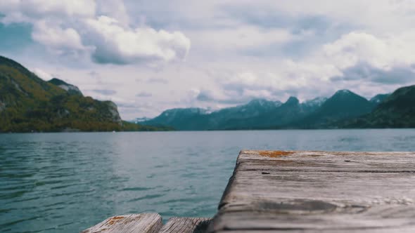 Wooden Pier on the Background of a Mountain Lake and Snowy Alps. Austria. Wolfgangsee Lake alt