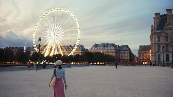 Young girl in the square at the Ferris Wheel alt