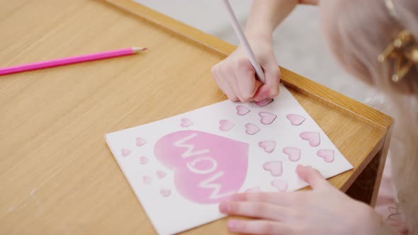 Little Girl Drawing Hearts on Mothers Day Card alt