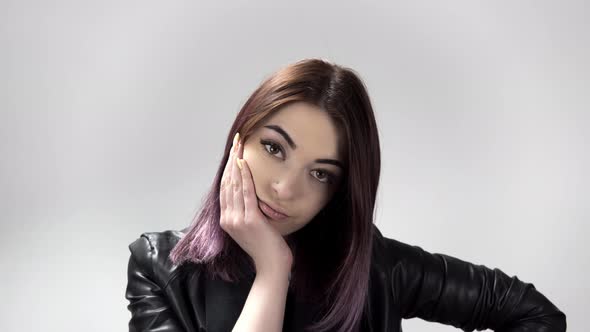 Portrait of Young Bored Woman with a Chin on Her Hand on White Background alt