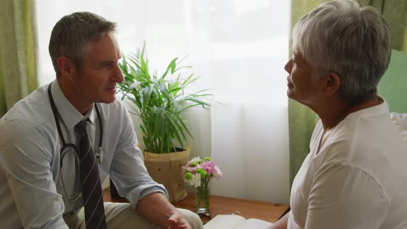 Doctor helping senior woman in her room of retirement house alt
