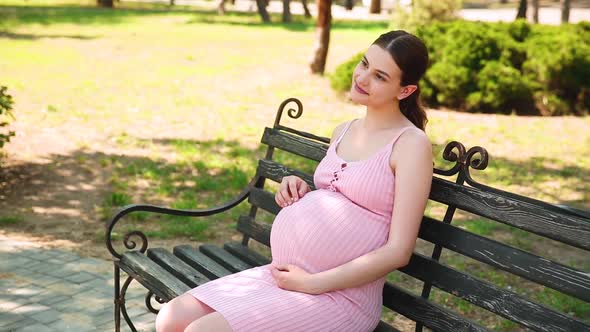 A Pregnant Girl is Sitting on a Park Bench and Her Stomach Begins to Hurt and She Begins to Breathe alt