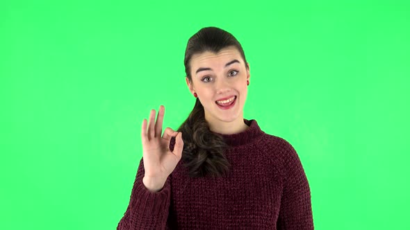 Smiling Girl Makes Sign Ok. Green Screen alt