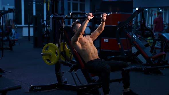 Fit young man lifting barbells doing workout at a gym. alt