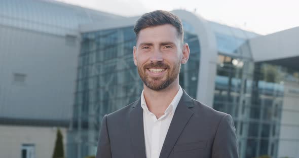 Portrait of Successful happy Businessman in Luxury grey Suit is smiling Charmingly to the Camera.
