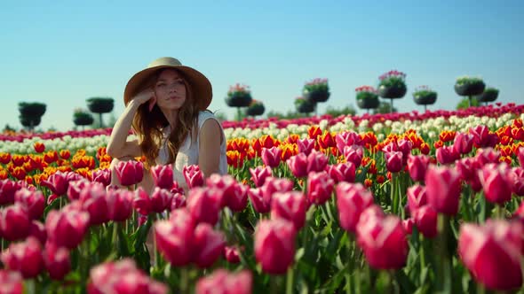 Relaxed Woman Sitting in Beautiful Spring Garden alt