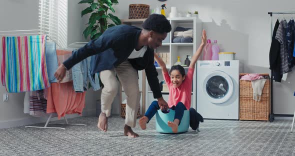 Father's Play with Child in Laundry Room Bathroom While Doing Household Chores alt