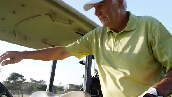 Golfer driving in his golf buggy alt