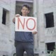 Portrait of Mixed-race Young Man Raising No Poster and Looking at Camera. Rack Focus Changes From - VideoHive Item for Sale