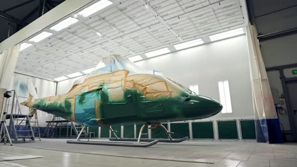 Military or Civilian Helicopter Stands in Spray Booth and is Painted Khaki Green alt