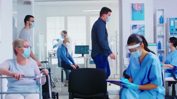 Doctor in Examination Room Listening Senior Patient Lungs with Stethoscope alt