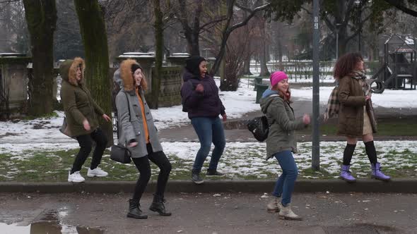 slow motion five young women multiethnic outdoor snow field having fun dancing alt