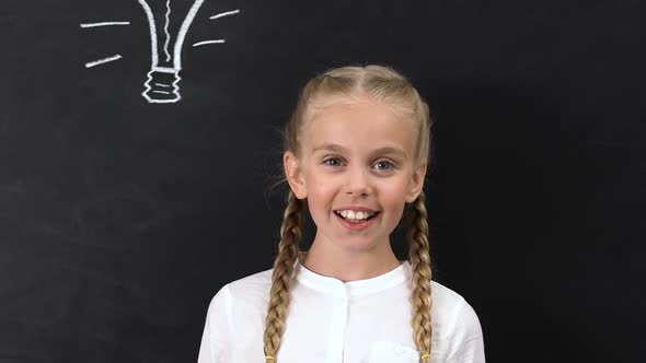 Inspired Little Girl Pointing Finger Into Bulb Painted on Blackboard, Creativity alt