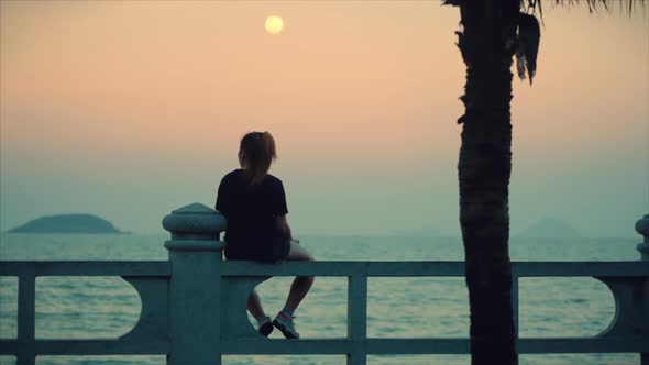 Woman Looking at Ocean View at Sunset alt