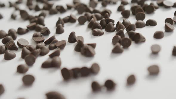 Video of close up of multiple chocolate chip over white background alt