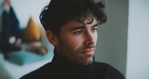 Close up of young man moving his head to music with girl in background alt