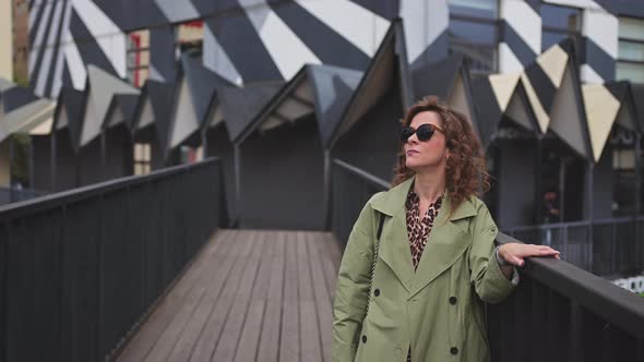 Young Stylish Woman in Glasses and Coat in Art Space