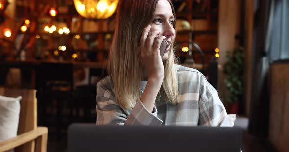 Young Caucasian Business Woman with Blonde Hair Working on Laptop in Cafe alt