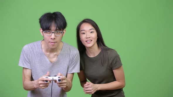 Young Asian Couple Playing Games Together