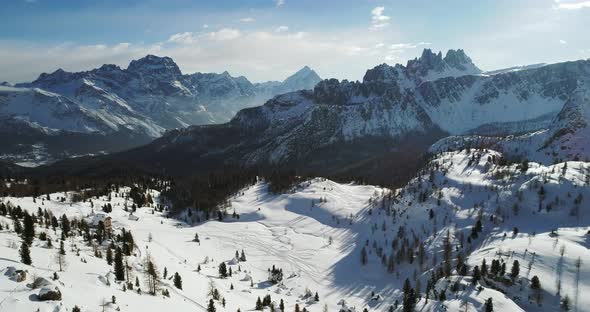 Forward Aerial to Snowy Alpine Valley with Woods Forest at Cinque Torri