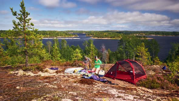 Long exposure man and woman tourists packing tent on their camping on Ladoga lake