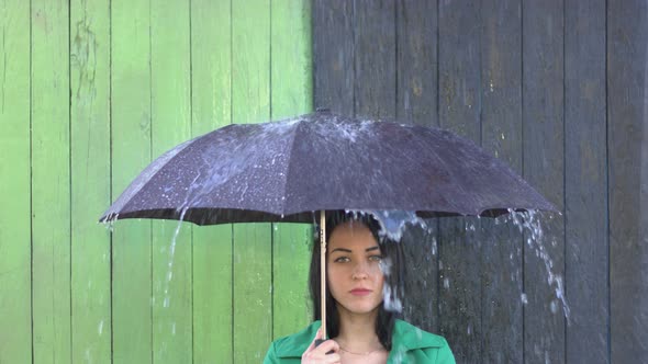 Heavy Rain pours on Girl Sheltered under Umbrella.