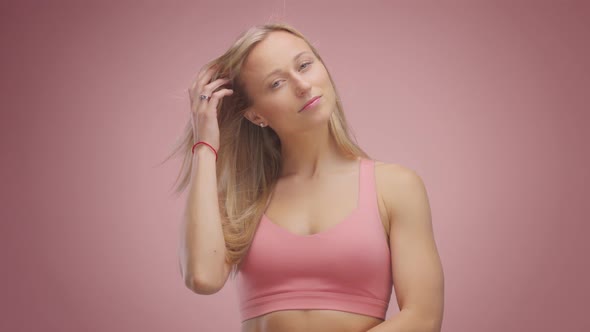 Blond Model in Studio on Pink Background with Hair Blowing in Air