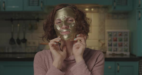 Young 30s Woman Taking Off Face Cosmetic Mask and Smiling Looking at Camera. Young Adult with Curly alt