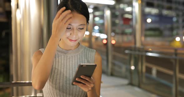 Woman using mobile phone at night alt