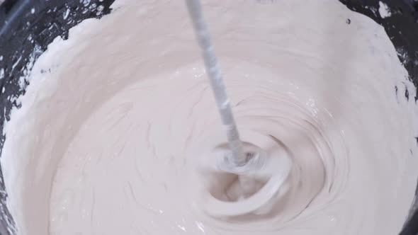 Closeup of a Bucket of Cement Mixing Cement in a Bucket