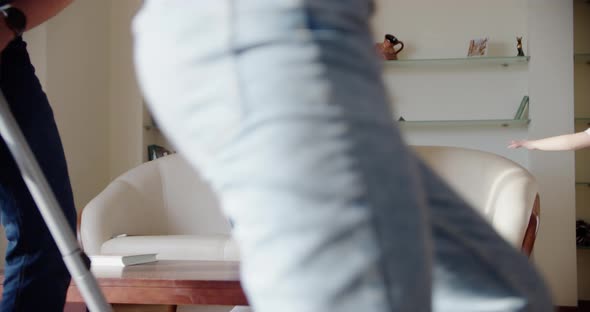 Tired Wife Sitting on the Couch Annoyed While a Noisy Little Daughter Screams Jumps on the Couch and alt